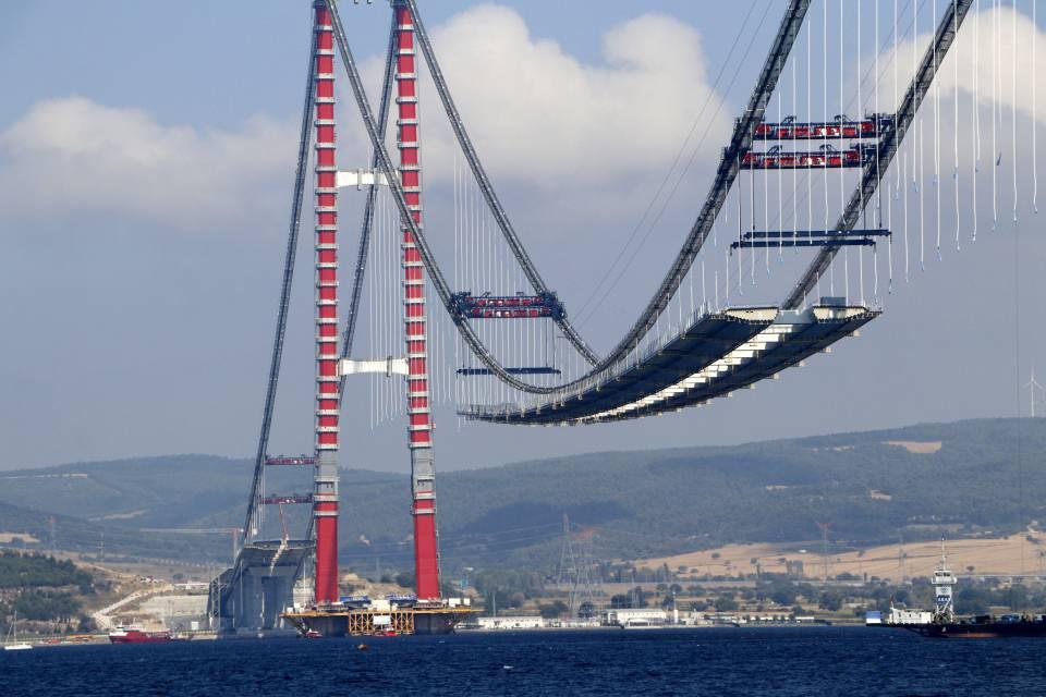<p><strong>DÜNYANIN EN UZUN ORTA AÇIKLIĞA SAHİP ASMA KÖPRÜSÜ OLACAK</strong></p>

<p>1915 Çanakkale Köprüsü, tasarımındaki inceliklerle de dünyada ilk olmaya aday. Cumhuriyetin 100'üncü kuruluş yıl dönümünü temsil eden 2023 metrelik orta açıklığıyla köprü tamamlanınca 'dünyanın en büyük orta açıklığına sahip asma köprüsü' unvanına sahip olacak. </p>
