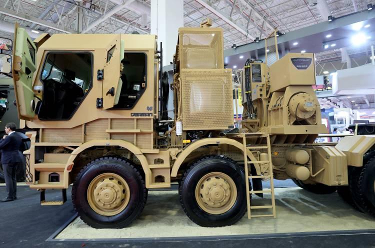 <p>2019'a kadar süren bir çalışma oldu ve ilk prototipimiz ortaya çıktı. Bunu 2021'de yeni ürettiğimiz ikinci jenerasyon Derman aracımız izledi. İlk aracımızın kabini tek kapılıydı, yeni aracımızın kabini hem tek hem çift kapılı olabilecek. İlk aracımızda ithal çelik kullanıyorduk, bu aracımızda yerli çelik kullanmayı planladık. Her iki araç da NATO standartlarında korumaya sahip. Bu araçları ağırlıklı olarak Türk Silahlı Kuvvetlerinin lojistik destek hizmetleri için programladık. İlk aracımız konteyner elleçleme aracı. Özellikle savaş bölgelerinde askerlerin zarara uğramadan birtakım kritik ürünleri taşıyıp geri getirmeleri için düşünülmüş bir araç. İkinci jenerasyon ürünümüz ise tank taşımaya yönelik bir araç. 70 tonluk tanklardan Altay tankına kadar taşıyabilecek kapasitede."</p>