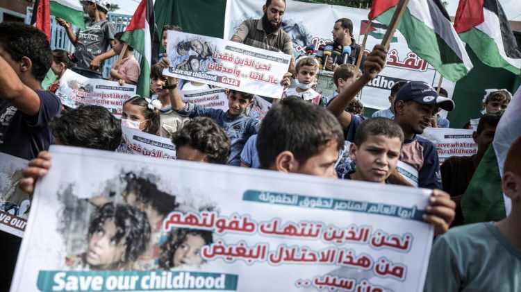<p>Filistinli çocuklar, "Çocukluğumuzu kurtarın", "Biz Filistin'in çocuklarıyız. Kendi topraklarımızda zulme uğruyoruz" ve "Niçin bizim yaralarımızı ve gözyaşlarımızı görmüyorsunuz?" yazılı pankartlar taşıdı</p>
