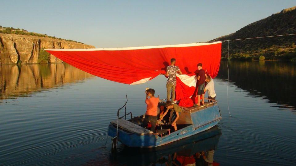 <p>Çelik halatı kanyonun bir yakasına yerleştirdikten sonra tekneyle gittikleri nehrin ortasına bayrağı denk getiren gençler, sonra halatın diğer ucunu gererek Kızılin köyündeki evin çatısına sabitledi. Bütün bölgeden görülebilen dev Türk bayrağını asan gençler, halatın başka noktasına ise 'Kürt-Türk kardeştir' yazılı pankartı astı.</p>

<p> </p>
