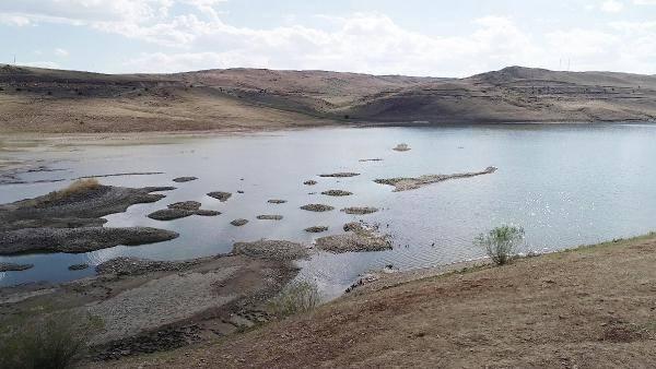 <p> Kuraklıkla gölde büyük oranda yaşanan su çekilme sonucu Aşağı Çat köyündeki mezarlar, gün yüzüne çıktı. Tahrip olan mezarlardaki kemikler de kıyıya vurdu.</p>
