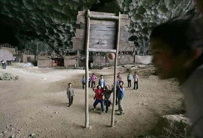 <p>Bir dağın yamacındaki devasa hacimli mağara içine tahta sınıflar inşa edilmiş. Teneffüsler için basketbol sahası da cabası.</p>
<p> </p>