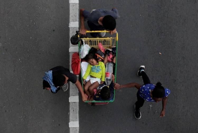 <p>1 Kasım'da göçmenler, Meksika'nın Hermenegildo Galeana kentinden Mexico City'ye giderken çocuklarını alışveriş sepetinde taşıyor.</p> <p> </p> 