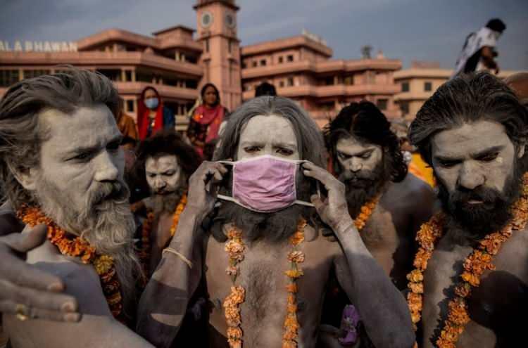 <p>12 Nisan'da Haridwar, Hindistan'da Hindular, Ganj nehrine dalmak için geçit töreninden önce maske takıyor. </p> <p> </p> 