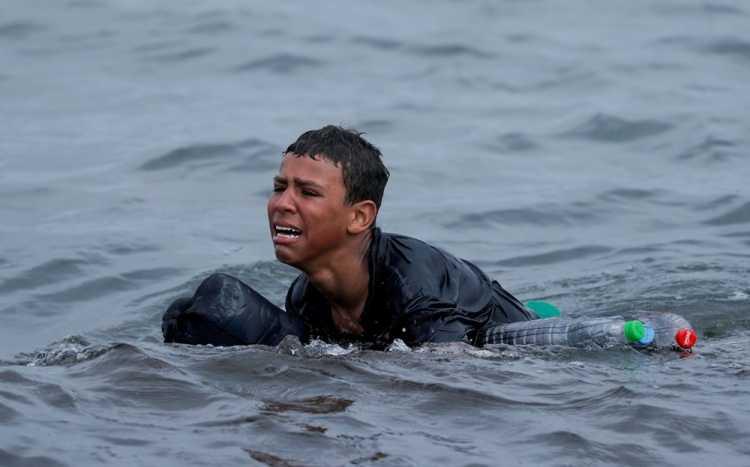 <p>19 Mayıs’ta Faslı bir çocuk, İspanya'nın Ceuta kentinde binlerce göçmenin sınırı yüzerek geçmesinden sonra, İspanya-Fas sınırı arasındaki çitin yakınında yüzen şişeleri kullanarak yüzerken ağlıyor.</p> <p> </p> 