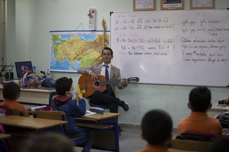 <p>Bazı nöbetlerinde bağlama ve gitar çaldığını anlatan Çuğu, şunları söyledi:</p>

<p>"Enstrümanlardan bir süre sonra sıkılmaya başladım. Daha farklı bir şey yapmalıyım diye düşündüm. Hem çocukları eğlendirip hem de kendim eğleneceğim bir şey düşündüm. Bir yerden bir palyaço kostümü geçti elime. Sonra sulu boya ile kendime makyaj yaptım. Tabii çocukların bundan haberi yok. Ben sınıfta kapıyı kapattım, öğle arasında makyajımı yaptım. O halde dışarı çıkınca birden çocukların yoğun ilgisiyle karşılaştım. Öyle ki çocuklar oynadıkları oyunları bırakıp benim etrafımda toplanmaya başladılar, kocaman bir öğrenci kalabalığı. Verdiğim mesajları daha güzel verebildiğimi fark ettim."</p>
