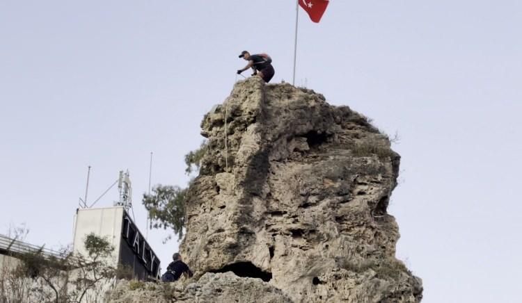<p> Bunun üzerine yaklaşık 25 metre yüksekliğindeki kayaya çıkan Kederli, bayrağı değiştirmeyi başardı. </p>
