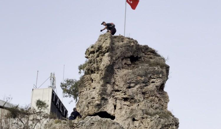 <p> Bunun üzerine yaklaşık 25 metre yüksekliğindeki kayaya çıkan Kederli, bayrağı değiştirmeyi başardı. </p>