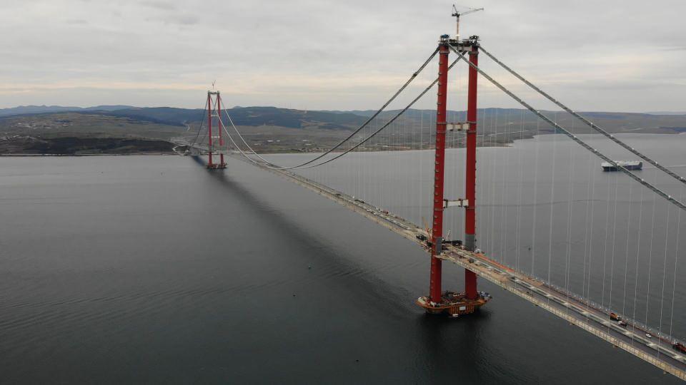 <p>Her biri 45 metre genişliğinde, 48 metre uzunluğunda ve 700 ton ağırlığındaki tabliye bloklarının bağlanacağı askı halatlarının ana halatlara montaj işlemi 6 Temmuz 2021’de başlamıştı. 12 Aralık 2021’de de Cumhurbaşkanı Recep Tayyip Erdoğan’ın katılımıyla, Asya ve Avrupa’daki kule ayaklarının orta açıklığına son tabliye bloğu yerleştirildi.</p>

<p> </p>
