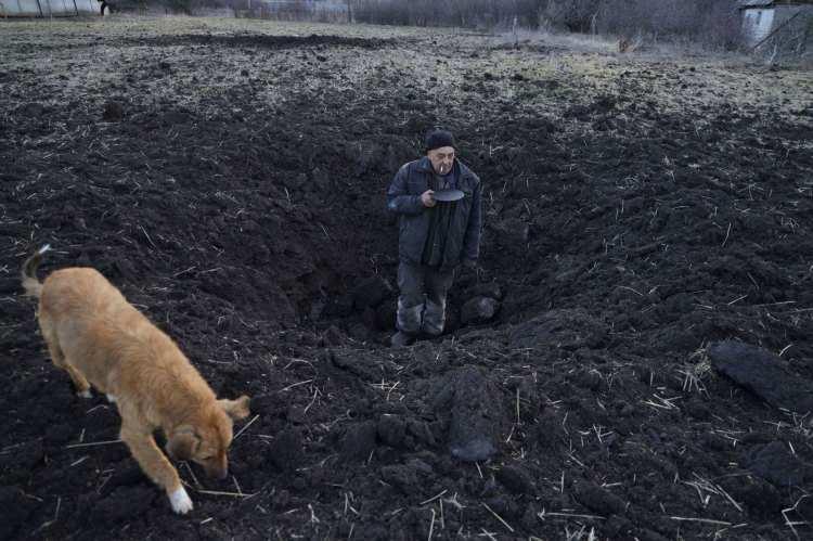<p>Yerel bir Ukraynalı vatandaş, köpeğiyle birlikte evinin arkasındaki tarlaya düşen Rus roketinin neden olduğu kraterin derinliğini ölçüyor.</p>

<p> </p>
