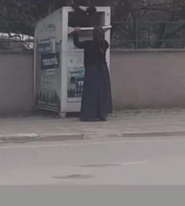 <p>Kadın, daha sonra çocuğu kaldırarak kumbaranın içine soktu. İçeriye giren çocuk ise kumbaradaki kıyafet poşetlerini tek tek dışarıda bekleyen kadına verdi. O anlar ise bir vatandaşın cep telefonu kamerası tarafından kaydedildi.</p>
<p> </p>