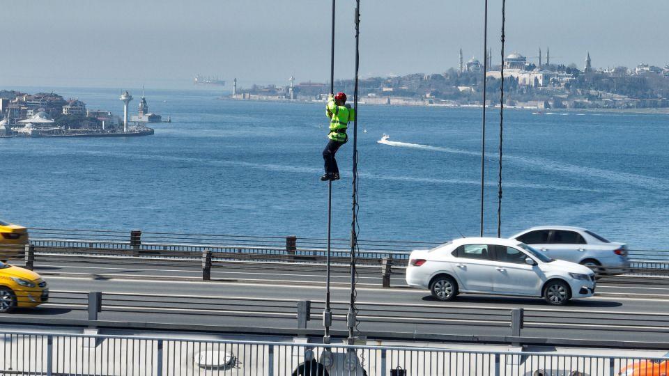 <p>İki kıtanın ortasından deniz seviyesinden yaklaşık 80 metre yükseklikte çelik halatlar üzerinde çalışan işçilerin nefes kesen mesaisi havadan görüntülendi. </p>