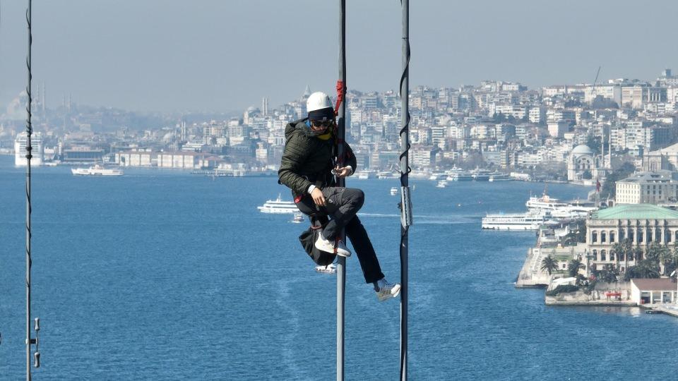 <p> Yaklaşık 80 metre yükseklikte çelik halatlara tırmanarak çalışan işçilerin zorlu mesaisi çekilen görüntülere yansıdı.</p>
