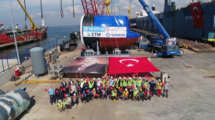 <p>İlk iki denizaltının, torpido kovanlarının yer aldığı bölüm, projenin ana yüklenicisi Alman ThyssenKrupp Marine Systems tarafından üretildi. 3, 4, 5 ve 6. denizaltılarda yer alacak Section 50 bölümü ise Türkiye'de STM ana alt yükleniciliğinde, Gürdesan'da üretiliyor.</p>