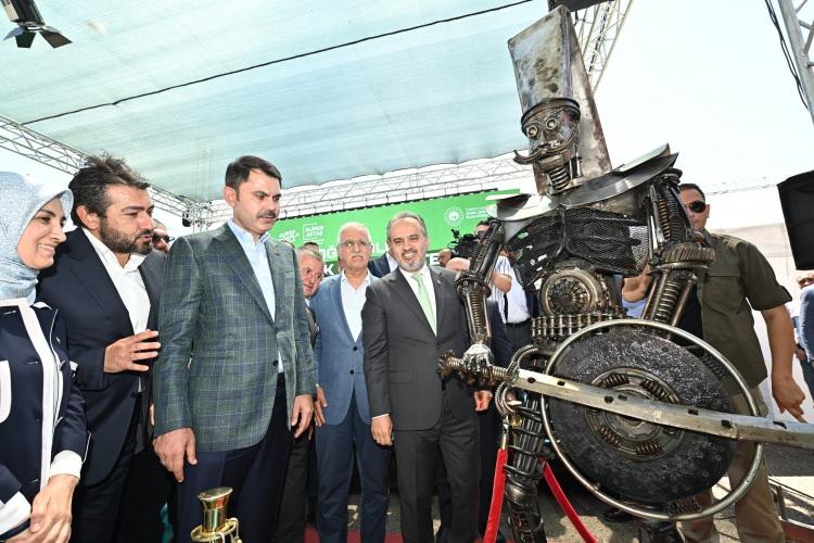 <p>Başarı hikayesi</p>

<p>Bursa Büyükşehir Belediyesi ve Uludağ Üniversitesi’nin de büyük katkılar sunduğu İklim Şûrasında, geri dönüşüme dair çok önemli bir hedef ortaya koyduklarını dile getiren Kurum, “2035 yılına kadar geri kazanım oranımızı yüzde 60’a çıkaracak, 2053 yılı itibariyle ön işleme tabi olmayan atıkları düzenli depolamaya kabul etmeyeceğiz. Bu kararlılık neden çok önemli? Bakın bugün Sıfır Atık Hareketiyle yüzde 13 olan geri kazanım oranımızı yüzde 28’ler seviyesine çıkardık. Bu 98 milyar liralık ekonomik kazanç demek. Milyonlarca ağacı kurtarmak demek, temiz hava, temiz su, temiz denizler demek. Bu bir başarı hikayesi. Bursalı kardeşlerimizin hizmetine sunduğumuz Doğu Bölgesi Entegre Katı Atık Tesisimiz hedefimize giden yolun taşlarını döşememize yardımcı olacak. </p>
