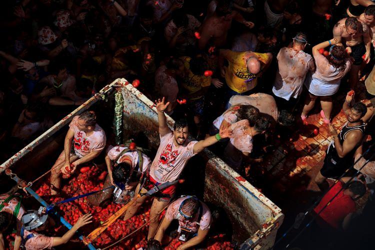 <p>İspanya’nın dünyaca tanınmış festivallerinden biri olan ve bu yıl 75'incisi düzenlenen “La Tomatina”ya katılan 20 bin kişi, dağıtılan 130 ton domatesi birbirine attı.</p>
