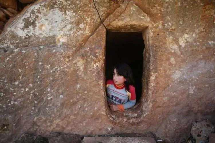 <p>9 yaşındaki Nihal, Suriye'de devam eden savaştan korunan sivillerin bulunduğu bir lahitte, pencereden dışarı bakarken.</p>