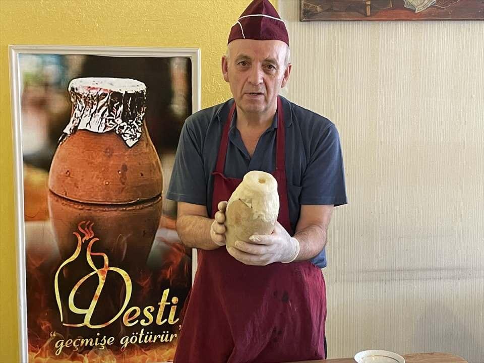 <p>Tereyağı ve defne yaprağı ilave edildikten sonra testinin ağzı mayasız hamurla kapatılıyor ve hava alması için üzerinden küçük bir delik açılıyor.</p>
<p> </p>
<p></p>