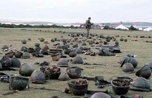 <p>Falkland Adaları'ndaki muharebelerin birinin ardından, Arjantinli askerlerin kasklarını kontrol eden İngiliz askeri,</p>

<p> </p>

<p>1982. </p>

