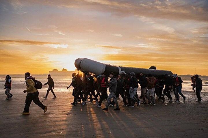 <p>Göçmenler, 12 Ekim 2022'de Fransa'nın kuzeyindeki Dunkirk yakınlarındaki Gravelines sahilinde İngiliz Kanalı'nı geçmeye hazırlanırken bir kaçakçılık botu taşıyorlar.</p>
