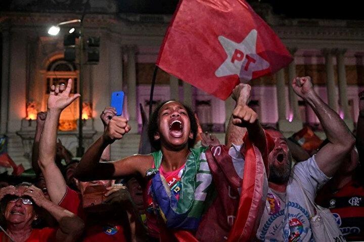 <p>Brezilya eski Cumhurbaşkanı (2003-2010) ve solcu İşçi Partisi (PT) adayı Luiz Inacio Lula da Silva'nın destekçileri, 30 Ekim 2022'de Brezilya'nın Rio de Janeiro kentindeki Cinelandia meydanında adaylarının cumhurbaşkanlığı ikinci tur seçimlerini kazanmasının ardından kutlama yapıyor. Seçim yetkilileri, Brezilya'nın tecrübeli siyasetçisi Luiz Inacio Lula da Silva'nın Pazar günü aşırı sağcı rakibini ülkeyi ikiye bölen seçimde kıl payı farkla yenerek cumhurbaşkanı seçildiğini söyledi.</p>
