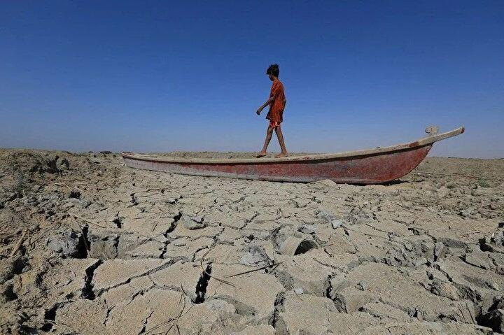 <p>Bir çocuk, 28 Haziran 2022'de Irak'ın güneyindeki Dhi Qar vilayetindeki Çibayiş bataklıklarının bir bölümünün kurumuş yatağında bırakılan bir teknede yürüyor. İran ve Türkiye'deki yağış azlığının Irak'taki kuraklığa etkisi görülor.<br />
 </p>
