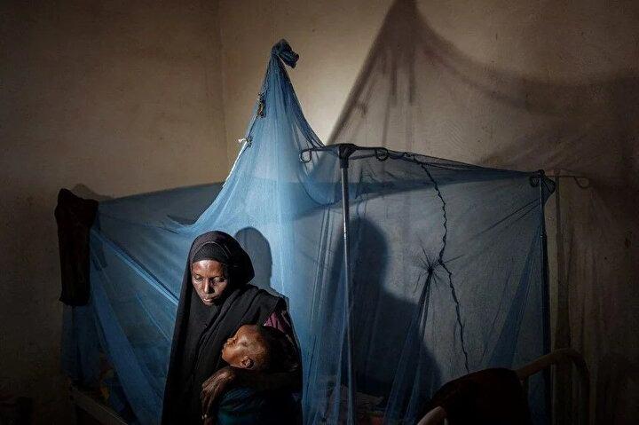 <p>31 yaşındaki Maimun Ali, 2 yaşındaki çocuğunu 14 Şubat 2022'de Somali'nin Baidoa kentindeki Sahal Macalin Ciise İstikrar Merkezinde kucağında tutuyor. Afrika Boynuzu'nu saran kuraklıktan en çok etkilenen bölgelerden biri olan güney Somali'nin kırsal bölgelerinden giderek daha fazla insan çaresiz, aç ve susuz Baidoa'ya akın ediyor.<br />
 </p>
