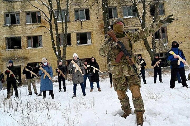 <p>Bir askeri eğitmen, 30 Ocak 2022'de Ukrayna'nın başkenti Kiev'de terk edilmiş bir fabrikada bir eğitim oturumu sırasında ellerinde Kalaşnikof tüfeklerinin tahta kopyalarını tutan sivillere eğitim veriyor.<br />
 </p>
