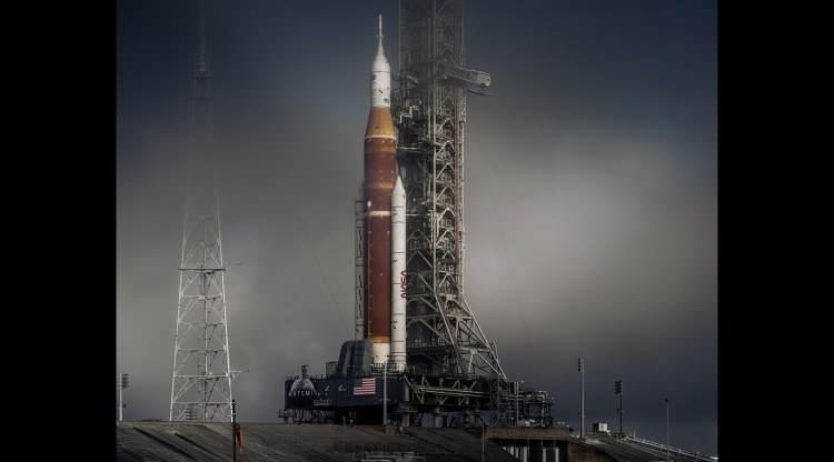 <p>Sabah sisiyle kaplı NASA’nın Uzay Fırlatma Sistemi (SLS), roket test edilmeyi beklerken Mart ayında Kennedy Uzay Merkezi’nin Fırlatma Kompleksi 39B’nin üzerinde beliriyor. 122 metrelik araç, NASA’nın Mars’a bir basamak taşı olan ve aynı zamanda aya ilk kadını ve ilk siyahi insanı indirmeyi amaçlayan Artemis programının temel taşı. İki güçlendirici ve dört ana motorla SLS, bir mürettebat kapsülünü 8,8 milyon librelik bir itme gücüyle aya doğru fırlatabilir – Apollo programının Satürn V roketinden yüzde 15 daha fazla. Her SLS yalnızca bir kez kullanılacaktır. Bu yıl yapılması planlanan mürettebatsız bir test uçuşu sırasında fırlatılan bu roketin parçalarının ya okyanusa düşmesi ya da güneş etrafında yörüngeye girmesi bekleniyor. <br />
<br />
Fotoğraf: Dan Winters/National Geographic</p>