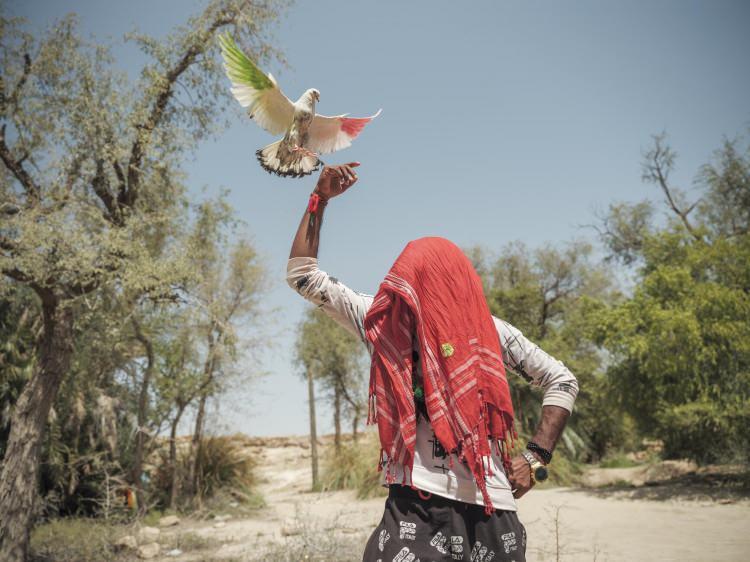 <p>26 yaşındaki Shadman Ali, Naing Sharif'in kutsal kaynağının yakınındaki şiddetli sıcaktan başını koruyor. <br />
<br />
Fotoğraf: Matthieu Paley /National Geographic</p>

<p> </p>
