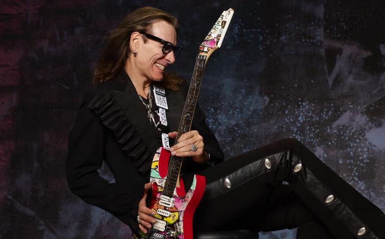 <p><span style="color:#000080"><strong>Birçok farklı dergi ve web sitesi tarafından hazırlanan en iyi gitarist listelerinde defalarca yer bulan Steve Vai, Alcatrazz, David Lee Roth ve Whitesnake, Ozzy Osbourne, Mary J. Blige, M83, Travis Barker, Devin Townsend, Zakk Wylde ve Terry Bozzio'nun da aralarında bulunduğu birbirinden ünlü isimlerle de çalıştı.</strong></span></p>
<p> </p>