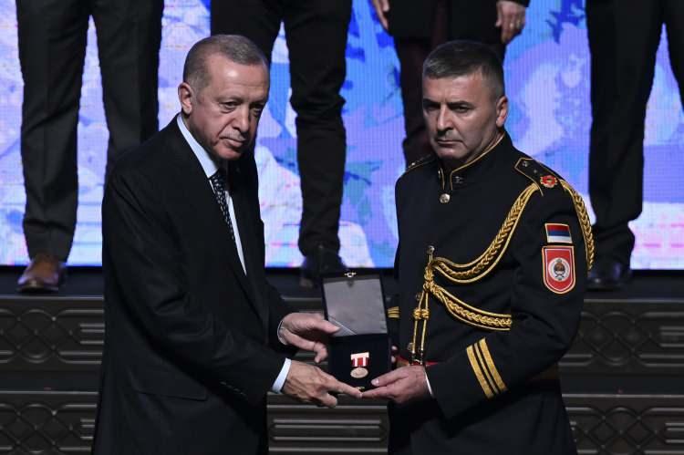 <p>Cumhurbaşkanı Erdoğan'ın açıklamaları şöyle:</p>

<p> </p>

<p>"Yurt dışından gelen misafirlerimiz olmak üzere her birinize teşekkür ediyorum. Kısa süre önce madalyalar ve nişanlara, üstün fedakarlık madalyasını da ekledik. İnsanlara teşekkür etmeyen Allah'a da şükretmez. Deprem bölgesindeki çabalarınız dolayısıyla sizlere en kalbi şükranlarımı sunuyorum. Şu an bu salonda bulunan misafirlerimiz madalya ve nişana layık görülen ilk grubu temsil ediyor. 35 bini aşkın personel bölgede bilfiil yer aldı. Toplam 275 bin kişi bölgede yer aldı. Kimi elinde avucunda ne varsa göndererek kimi bölgeye gelerek desteğini sundu.</p>
