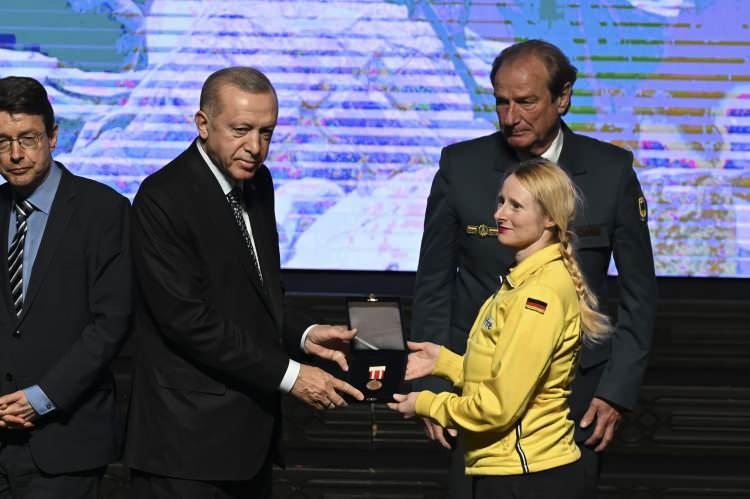 <p>Cumhurbaşkanı Recep Tayyip Erdoğan, Beştepe Millet Kongre ve Kültür Merkezi'ndeki Devlet Üstün Fedakarlık Madalyası Tevcih Töreni'nde konuştu. Erdoğan, Kahramanmaraş merkezli depremlerde arama kurtarma faaliyetlerinde bulunan ve üstün başarı gösteren 55 bin kişiye madalya ve nişan takdim edileceğini söyledi. Erdoğan, deprem bölgesinde görev alan yabancı ülke personellerine teşekkür ederek "İnsan üstü gayretlerinizi unutmayacağız" dedi.</p>
