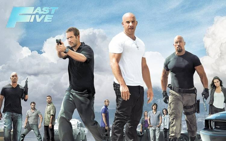 <p><span style="color:#4B0082"><strong>6 - Hızlı ve Öfkeli 5: Rio Soygunu (2011)</strong></span></p>
<p><span style="color:#4B0082"><strong>(Fast Five)</strong></span></p>
<p><span style="color:#000080"><strong>ABD'den Rio'nun yoksul mahallelerine sığınan kahramanlarımız dahil oldukları bir iş nedeniyle şehrin en belalı adamının hedefi haline geliyorlar. Ama av konumunda kalmaktansa, çılgın bir planla, karşı saldırıya geçmeye karar veriyorlar. “Hızlı ve Öfkeli 5”, ekibin toplanması, plan ve hazırlık dönemleriyle soygun filmlerinin şemasını takip ediyor. Polis dahil tüm Rio'yu kontrol eden mafya patronu, bir diktatör gibi çiziliyor. Kahramanlarımız ise yerel halk desteğiyle harekete geçen Amerikalı kovboylara benziyor. Rio'nun yoksul bölgelerinin tekinsiz atmosferini, inişli çıkışlı dar sokaklarını, çatılarını filmin öyküsüne çok iyi yerleştiren yönetmen Justin Lin, aksiyon konusunda seyirciye beklediğini fazlasıyla veriyor. Finale doğru, film Rio'nun geniş caddelerine açıldıkça, çatışma, patlama ve kovalamaca sahneleri de zirveye çıkıyor. Sonuç olarak serinin beşinci filmi, güzel kızları, hızlı otomobilleri, esprili diyalogları, “cool” erkekleriyle bol miktarda adrenalin içeren bir aksiyon sineması örneği.</strong></span><br />
<span style="color:#8B4513"><strong>Toplam bilet sayısı: 665.624 </strong></span><strong><a href="https://www.yasemin.com/" target="_blank"><span style="color:rgb(255, 255, 255)">(Yasemin.com)</span></a></strong></p>
