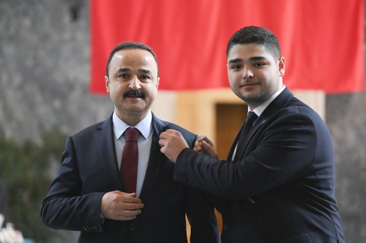 <p>Meclis'e gelen MHP Ordu Milletvekili Naci Şanlıtürk, mazbatasını görevlilere teslim ederek kayıt yaptırdı. Kayıt işlemi sonrası Şanlıtürk'e rozetini oğlu Naci Emir Şanlıtürk (sağda) taktı.</p>

<p> </p>
