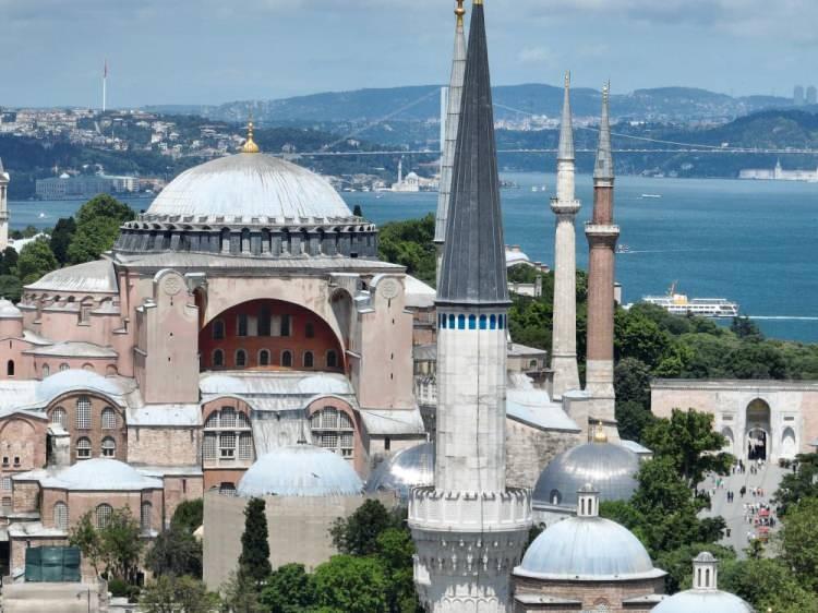 <p>Karşılıklı ezan okumanın bir sebebi de budur. Karşıda bir müezzin bir ses ile başlarsa sizde kendi kendinize ezan okursanız karışır. Müzik kulağı iyi olan insanlar hemen etkilenirler. Dolayısıyla bu işin düzgün olabilmesi için de karşılıklı okunması gerekir. Daha önce Sultanahmet’le başlıyorduk Ayasofya ile davam ediyorduk şu an da Ayasofya Camii başlıyor. Daha önce Ayasofya’nın arkasında bir mescidimiz vardı, 1991 yılından bu yana orada ezan okunuyor.</p>