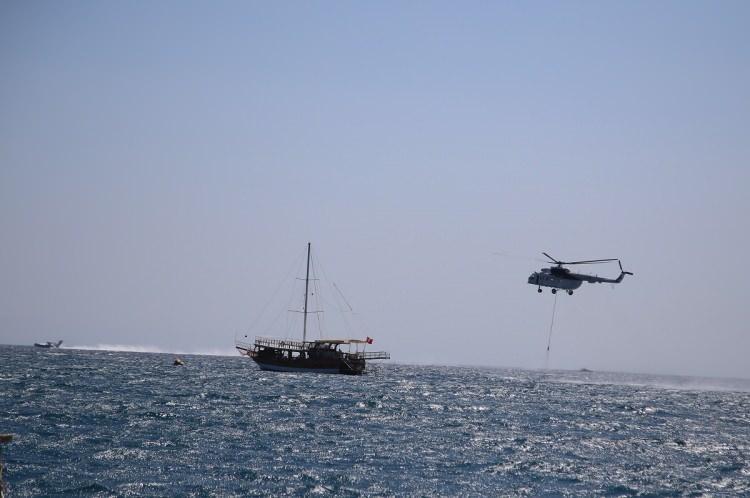 <p>Gece boyunca arazöz ve iş makineleriyle karadan yürütülen çalışmalara, sabahın ilk ışıklarıyla hava araçları da katıldı. Ekipler, 11 uçak, 22 helikopterle denize alçalarak su aldıktan sonra alevlerin üzerine boşaltıyor.</p>