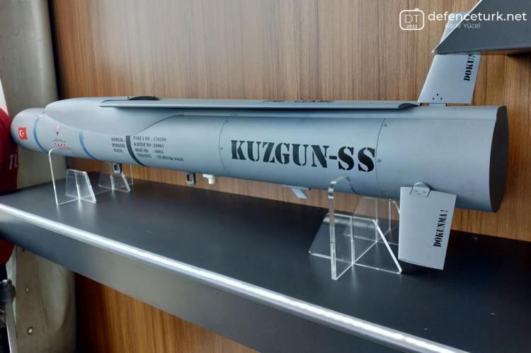<p><strong>KUZGUN-SS</strong></p>
<p> </p>
<p>EFES-2022 tatbikatında Defence Turk tarafından KUZGUN-SS mühimmatının AKSUNGUR SİHA’ya entegre edilerek test edilmesinin planlandığı bilgisi edinilmişti. İtkisiz bir mühimmat olan KUZGUN-SS, itki sisteminin yokluğundan dolayı oluşan ağırlık boşluğunu ek harp başlığı ile dengeliyor, KUZGUN-TJ gibi 14 kg’lik harp başlığı modülü kullanan KUZGUN-SS’de iki adet 14 kg’lik harp başlığı (toplam 28 kg) bulunuyor.</p>
<p> </p>
<p>SİHA’ların yanında booster ile karadan/denizden atılabilecek KUZGUN-SS, 0.2 Mach hız ve 20000 ft irtifadan 40 km menzil ve 2 dakikalık varış süresine sahip olacak.</p>