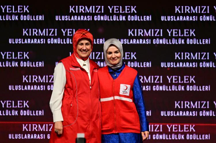 <p>Programda Kızılay Genel Başkanı Fatma Meriç Yılmaz (solda) Aile ve Sosyal Hizmetler Bakanı Mahinur Özdemir Göktaş'a (sağda) Kızılay gönüllüleri tarafından örülen kırmızı yelek hediye etti.</p>
