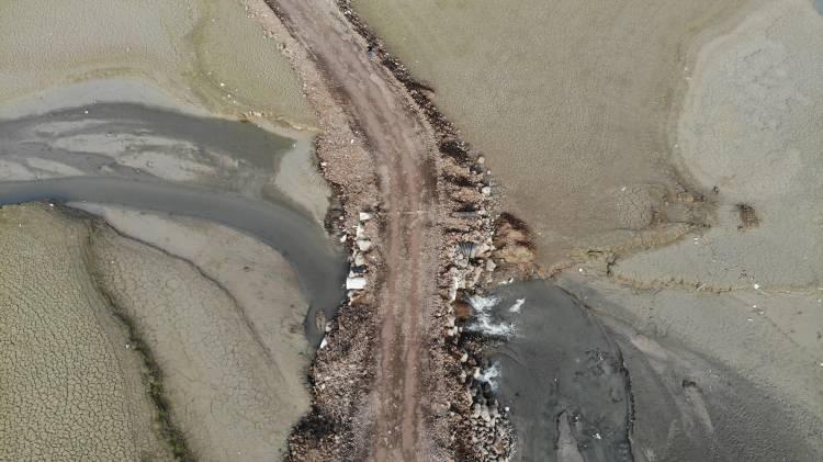 <p>Stabilize yolun tekrar ortaya çıkmasıyla zaman ve yakıttan tasarruf sağladıklarını belirten kapıcı köyü sakini Tarık Gündoğdu," Yolumuz çok uzun 13 kilometre fazladan yakıt yakıyoruz. Bahar aylarında bu yolu baraj alıyor, bütünüyle sular altında kalıyor. Köprümüzün olması daha iyi olurdu. Suların buradan çekilmesi yılsonunu buluyor. Aralık ayı gelene kadar burası sular altında kalıyor ve bizim için zorluk oluyor" şeklinde konuştu.</p>
