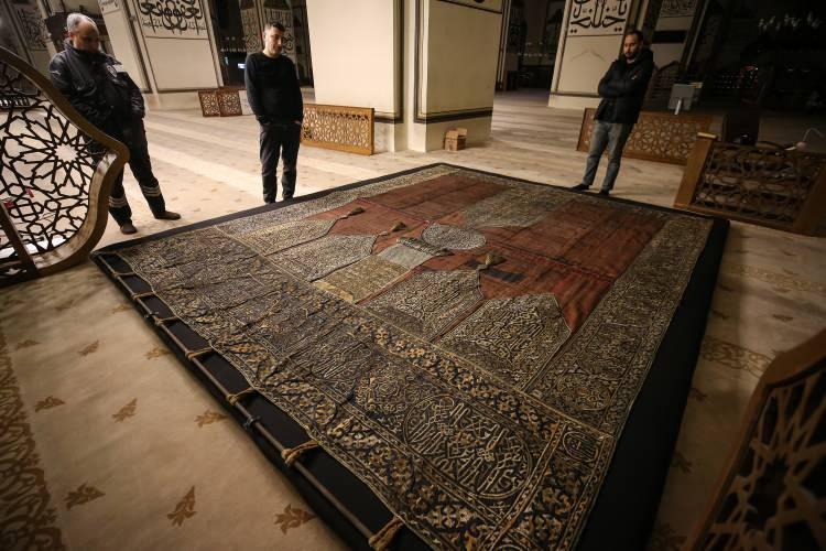 <p>Yıprandığı için düşen püsküllerin tutanakla Vakıflar Bölge Müdürlüğü ekiplerince emanete alındığını belirten Şanlı, "Batı girişinde 'Vav'ın yanında asılı olan Kabe kapı örtüsünün püskülleri zamanla yıpranmış ve düşmüştü. Daha sonra Vakıflar Bölge Müdürlüğü bunu koruma altına aldı. Bunu yapabilecek ustayı aradık. Vakıflar Bölge Müdürlüğümüzün çalışanlarının da hazır bulunduğu, maliyetini de derneğimizin karşılamasıyla buradaki püsküllerimiz, o tarihi emanet yine eskisi gibi koruma altına alındı. Halkımızın ziyaretine sunuldu." diye konuştu.</p>