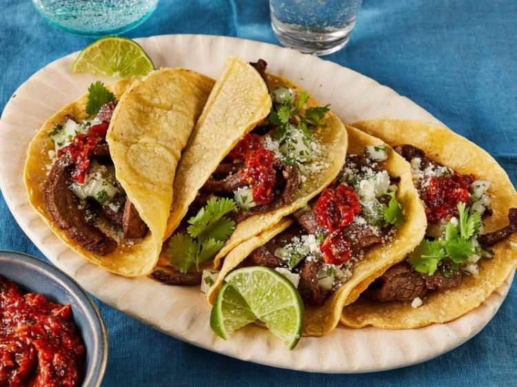 <p><span style="color:#B22222"><strong>CARNE ASADA TACOS (KAVRULMUŞ ETLİ TACO) / MEKSİKA</strong></span></p>
<p><strong>Tarihte ilk taco olarak geçmektedir. Et, mısır tortillasına yerleştirildi ve üzerine guacamole, soğan, kırmızı biber ve limon ekşenmektedir. </strong></p>