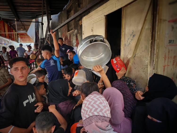 <p>Deir Al Balah kentindeki çocuklar, hayır kurumlarının dağıttığı yemeklerden ailelerine bir kap alabilmek için kuyrukta bekledi.</p>
