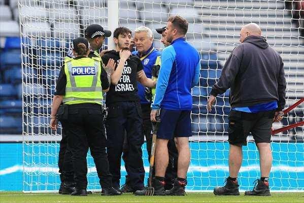 <p>Glasgow kentinde bulunan Hampden Park'ta İskoçya ile İsrail arasında oynanan Avrupa Kadınlar Futbol Şampiyonası (EURO 2025) eleme maçı sırasında, "İsrail'e Kırmızı Kart" yazılı tişört giyen Filistin destekçisi bir kişi, kendini kale direğine zincirledi.</p>
