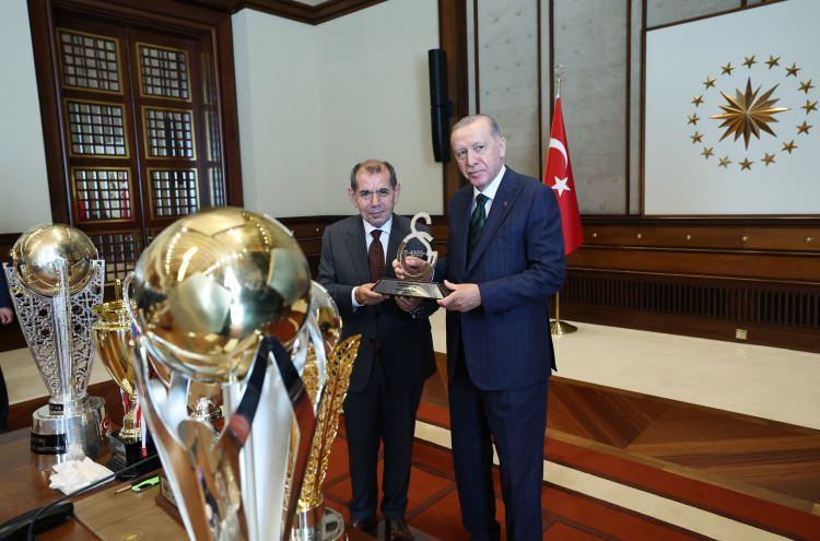 <p>Galatasaray Başkanı Dursun Özbek, üzerinde isminin yazılı olduğu 53 numaralı çubuklu Galatasaray formasını Erdoğan'a hediye etti. Erdoğan ve Galatasaray heyeti, takımın bu sezon kazandığı kupalarla birlikte fotoğraf çektirdi.</p>
