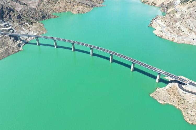<p>Yusufeli Barajı ve HES ile kapanan vadi g&uuml;zerg&acirc;hındaki yolların yerine yeniden inşa edilen karayolunda iki yakayı birleştiren Yusufeli Merkez Viyad&uuml;ğ&uuml;&rsquo;n&uuml;n trafiğe a&ccedil;ılması ile birlikte Yeni Yusufeli il&ccedil;esi ve &ccedil;evre k&ouml;yler ile Artvin arasındaki 16,2 kilometrelik yolun 685 metreye ineceğini de kaydeden Bakan Uraloğlu,<strong><em> &ldquo;Yusufeli merkezden Artvin&rsquo;e gidiş-geliş s&uuml;resini 25 dakika kısaltan viyad&uuml;ğ&uuml;m&uuml;z ile vatandaşlar hem zamandan hem de yakıttan tasarruf yaparak konforlu bir şekilde seyahat edecek.</em></strong>&rdquo; dedi.</p>
