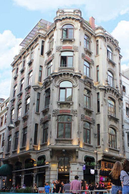 <p><span style="color:#0000CD"><strong>RAGIP PAŞA PARTMANI</strong></span></p>

<p>Beyoğlu İstiklal Caddesi’nde yer alan Ragıp Paşa Apartmanı; 1900’lü yılların başında, II. Abdülhamit’in özel kalemi, mabeyin başkâtibi olarak görev yapan Eğribozlu Sarıca Ragıp Paşa tarafından yaptırılmıştır. Beyoğlun’da Afrika Pasajı, Rumeli Pasajı ve Anadolu Pasajı’nın yanı sıra İstiklal Caddesi üzerindeki bu apartmanı da Ragıp Paşa yaptırmış. 1900 yılında Mimar Aram Caracach ve Mimar İsac Caracach tarafından çizilen bu beş katlı tarihi apartman; Art Nouveau sanat akımının ülkemizdeki ilk örneklerindendir. Yapı malzemesi tuğla üzeri taş kaplama olan Ragıp Paşa Apartmanı’nın dış cephesini süsleyen zarif kıvrımlar ve bitkisel motifler hala orijinalliğini korumaktadır. Yapının her kattaki pencereleri farklı olarak tasarlanmış ve geometrik şekiller ile bezenmiştir. Ragıp Paşa Apartmanı’nın günümüzde giriş katında bir kafe bulunuyor, üst katları ise otel olarak hizmet veren yapı ; 100 yılı aşkın tarihiyle herkesi kendine hayran bırakmaktadır.</p>
