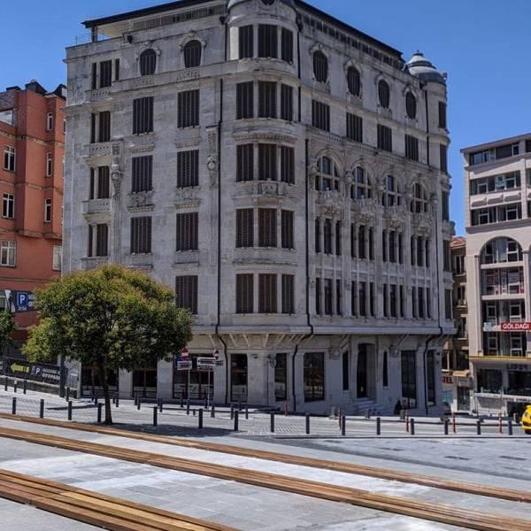 <p><span style="color:#0000CD"><em><strong>TRAJİK BİR HİKAYENİN ŞAHİDİ: FREJ APARTMANI</strong></em></span></p>
<p>Şişhane'deki Bankalar Caddesi ile Meşrutiyet Caddesi'nin kesiştiği noktada bulunan Frej Apartmanı, 1905 – 1906 yılları arasında Hanna Frej tarafından Kyriakidis adlı bir mimara yaptırılmış. Art nouveau’nun Almanya’daki karşılığı olan Jugendstil tarzında yapılmış olan bina dönemin sosyetesinde yer alan sayılı zenginlerden Frej ailesine aittir. 4 katlı Frej Apartmanı'nın mimarisinde yer alan çocuk figürlerinin aile çocuklarını yansıttığı düşünülüyor. Lübnanlı Selim Hanna Frej’in kızı Angel, Feridun Dirimtekin ile evlendi. Evlilikle beraber Aysel adını alan Angel, Feridun beyin emekli olmasıyla ailesinden kalan Frej Apartmanı’nı satar ve eşiyle birlikte Nişantaşı'nda bir apartman dairesine taşınır. Feridun Bey, bir süre sonra belediyenin açtığı bir çukura düşer, kalçasını kırar ve tedavi sürecinde kalp krizi geçirerek hayatını kaybeder. Bir süre akıl hastanesinde yatan Aysel Dirimtekin daha sonra bir huzurevine yatırılır. Ancak onu da eşi gibi trajik bir son beklemektedir. Bir kanalizasyon çukurunu göremeyip içerisine düşen Aysel Hanım, önce ayağını kırar sonra da kısa bir süre içinde vefat eder</p>
<p> </p>