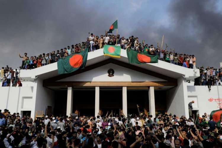 <p>Hükümet karşıtı protestocular, 5 Ağustos'ta Dakka'da Başbakan Şeyh Hasina'nın sarayına baskın düzenlerken Bangladeş'in ulusal bayrağını taşıyorlar. </p>

<p> </p>

<p><span style="color:rgb(163 165 169/var(--tw-text-opacity))">KM Asad—AFP/Getty Images</span></p>

<p> </p>
