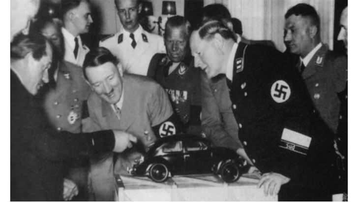 <p><span style="color:#B22222"><strong>ADOLF HİTLER VOLKSWAGEN BEETLE'I İNCELİYOR </strong></span><strong>| 1934</strong></p>
<p> </p>
<p>Ferdinand Porsche (en soldaki) ilk Volkswagen Beetle'ı Hitler'e gösterirken</p>